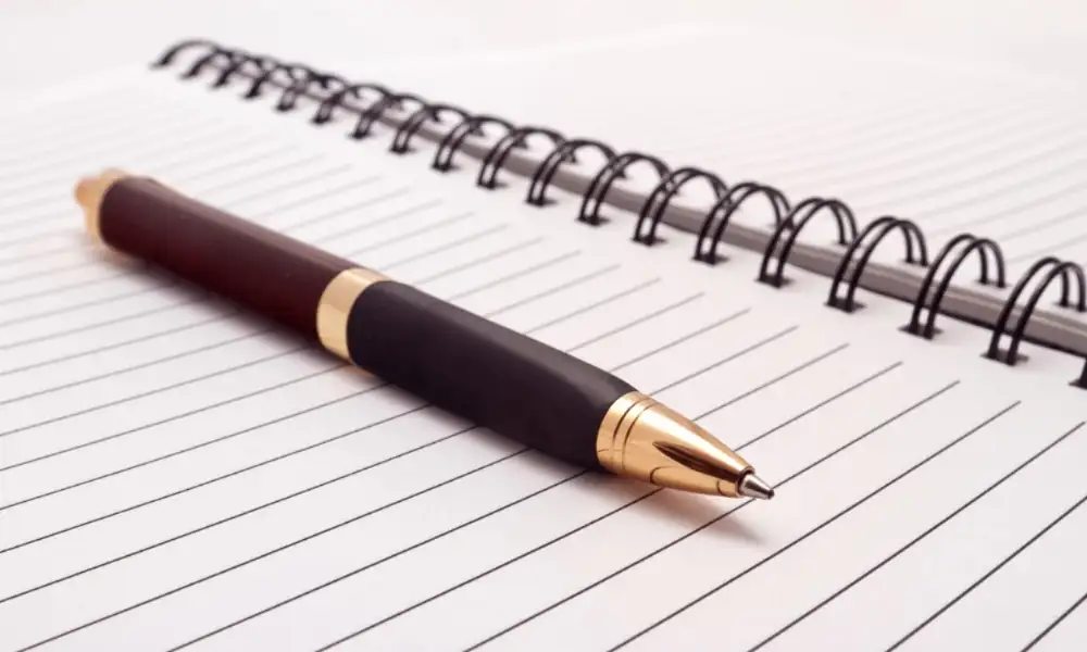 Kugelschreiber liegt auf einem offenen Notizbuch – Symbol für Reflexion und persönliche Entwicklung